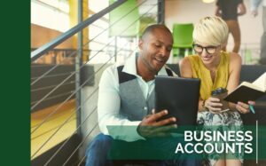 Man and woman smiling at a tablet in a coworking space - Small Business Accounts Ad